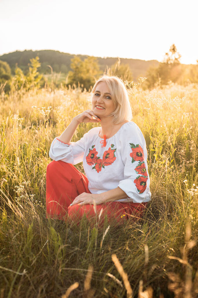 portrait of happy joyfull mature woman in countryside during beautiful sunset - Foto, Bild