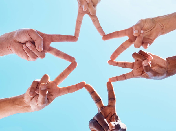 Blue sky, hands and star peace star with community in support of partnership, collaboration and goal. Hand, business people and innovation sign with business people in teamwork, business and startup. - 写真・画像