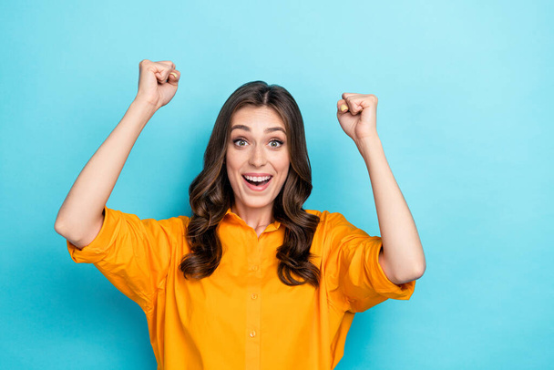 Photo of delighted overjoyed lady raise fists attainment luck scream yeah hooray isolated on blue color background. - Photo, Image