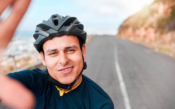 Selfie, fitness and man cycling in the road on the mountains in Switzerland for adventure, peace and freedom. Face portrait of a young, happy and free athlete with photo while training in the street. - Foto, immagini