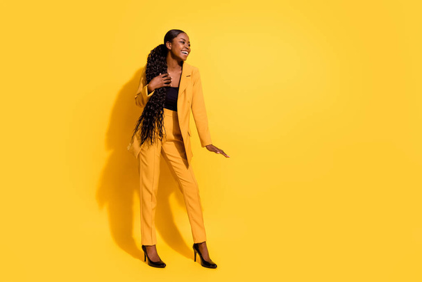 Full length photo of funky young lady stand show small wear suit high heels isolated on yellow background. - Foto, afbeelding