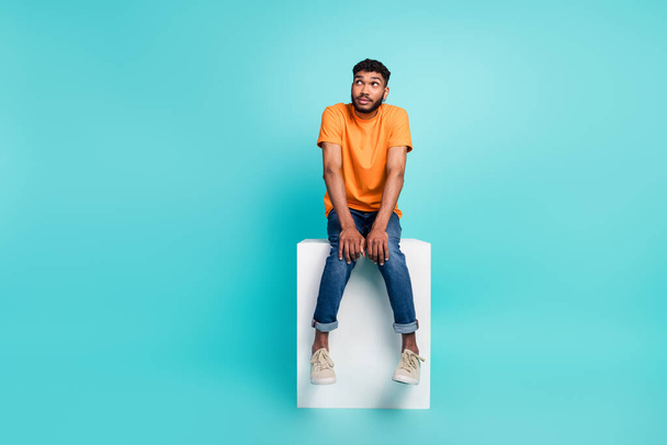 Full size portrait of minded shy person sit podium look interested empty space isolated on teal color background. - Foto, imagen
