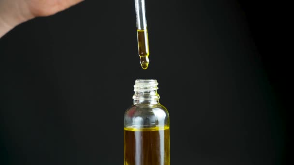 Natural oil for the care of eyelashes, eyebrows, facial skin drips into a glass jar of pipette. - Footage, Video