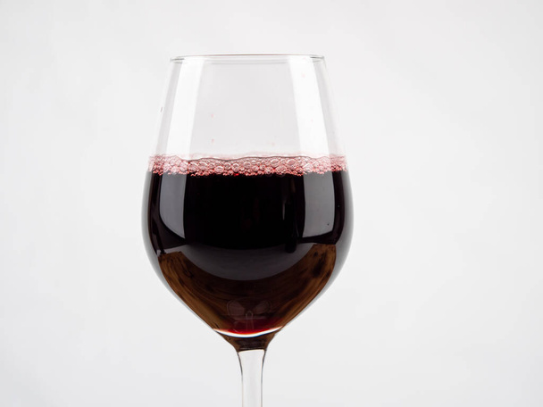 Un verre de vin sur fond blanc. Gobelet en verre avec vin. - Photo, image