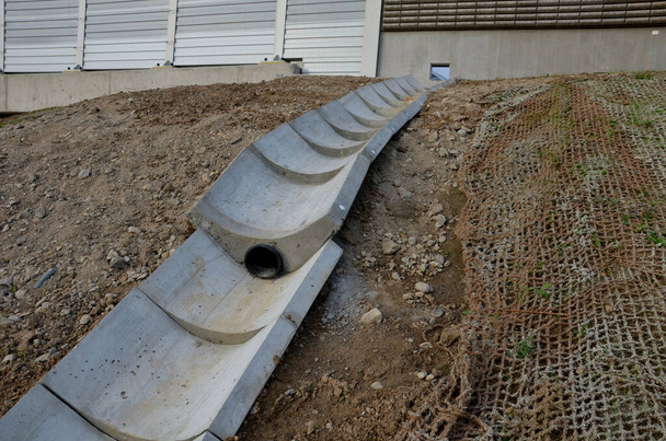 freeway bridge drainage. A sound-absorbing wall with holes lets water through. gutters collect water from gutter of water line. pipe with flexi rubber connection. slowing down flow of water roughening - Photo, Image