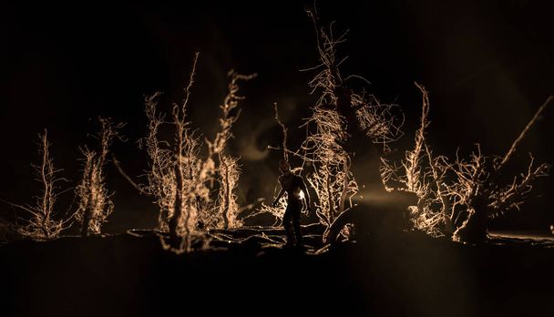 Силуэт человека, стоящего в темном лесу. Концепция Хэллоуина ужасов. Странный силуэт в темном жутком лесу ночью - Фото, изображение