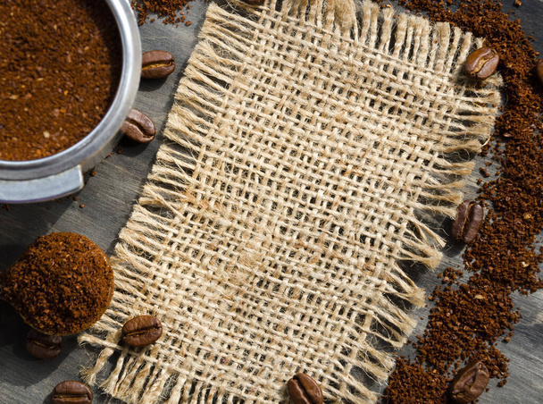 Coffee cone with ground coffee lie on coffee beans on burlap. Photo for advertising a coffee shop. Menu of coffee drinks. - Foto, Imagen