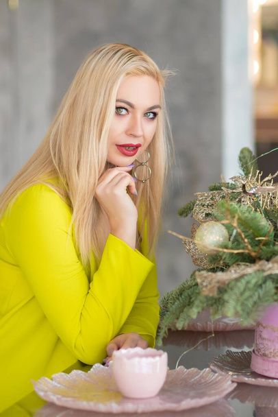 Happy young blonde woman with champagne on the Christmas kitchen - Photo, Image