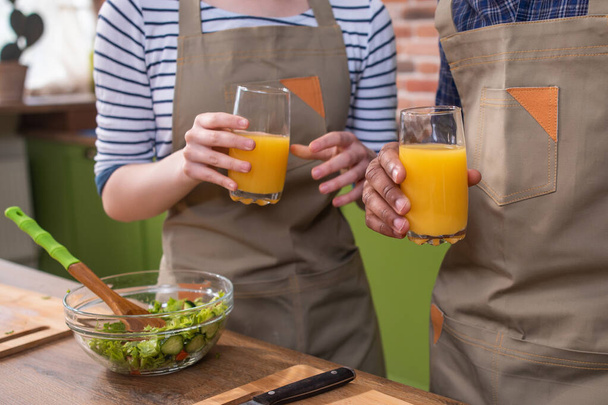 An anoymous hand is filling fresh orange juice to glass. - Foto, imagen