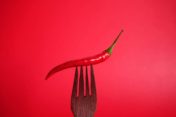 chile rojo Pimienta sobre tenedor de madera sobre fondo rojo - Foto, Imagen