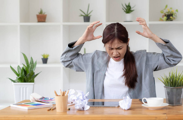 Mad Angry Stressed joven asiática diseñadora gráfica o empresaria con un papel arrugado sobre la mesa insatisfecha con su trabajo, se quejó de su jefe, consiguiendo un problema de trabajo.. - Foto, imagen