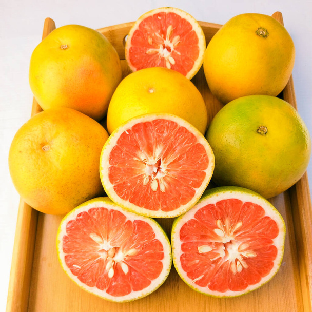 グレープフルーツ柑橘類ジューシーな新鮮な赤い柑橘類の生全体と半分スライス栄養と健康有益な農業食品のクローズアップ画像写真  - 写真・画像