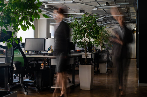 Blurred female figures in motion in the office - Photo, Image