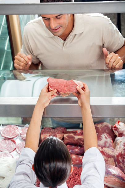 Butcher Showing Fresh Red Meat To Customer - Fotoğraf, Görsel