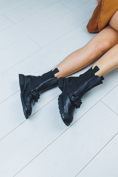 Gros plan des jambes féminines en bottes en cuir noir. Chaussures automne femme. - Photo, image