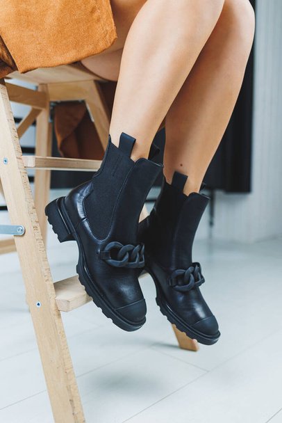 Női lábak fekete bőrcsizmában. Női őszi cipő. - Fotó, kép