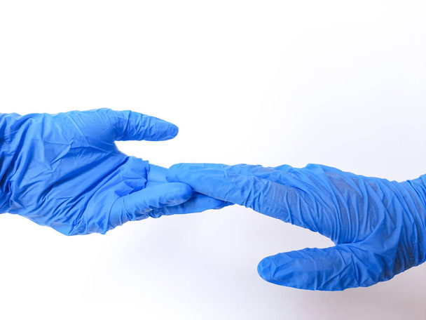 Дві руки в блакитній рукавичці, майже тримаються за руки. Ізольовані на білому тлі. Простір для тексту
 - Фото, зображення