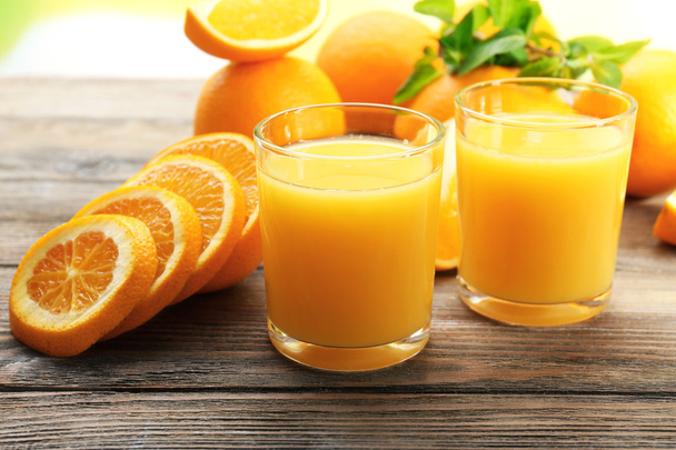 Glass of orange juice and slices on wooden table background - Foto, Bild