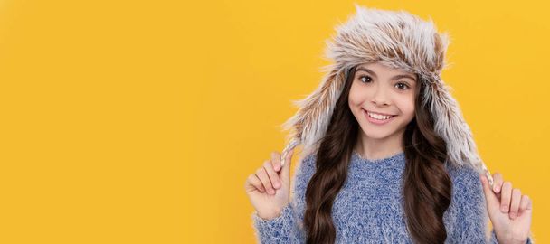 teen girl in knitwear on yellow background. portrait of child wearing warm clothes. Child face, horizontal poster, teenager girl isolated portrait, banner with copy space - Photo, Image