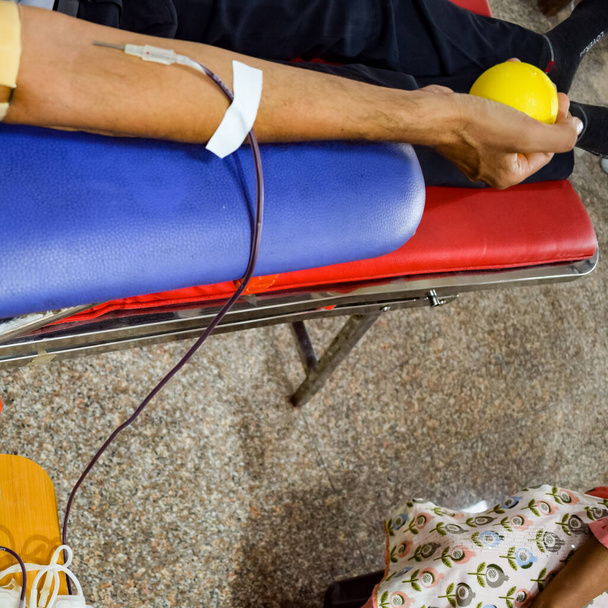 Dawca krwi na obozie krwiodawstwa trzymany z odbijającą się piłką trzymającą w dłoni w Świątyni Balaji, Vivek Vihar, Delhi, Indie, Obraz dla Światowego Dnia Dawcy Krwi 14 czerwca każdego roku, Obóz krwiodawstwa - Zdjęcie, obraz