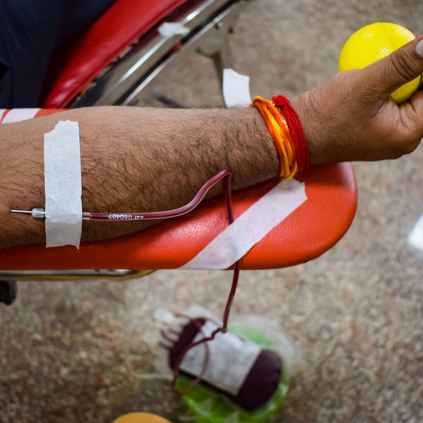 Verenluovuttaja verenluovutusleirillä, jota pidettiin pomppupallolla Balajin temppelissä, Vivek Viharissa, Delhissä, Intiassa, Kuva maailman verenluovutuspäivästä 14. kesäkuuta joka vuosi, verenluovutusleiri - Valokuva, kuva