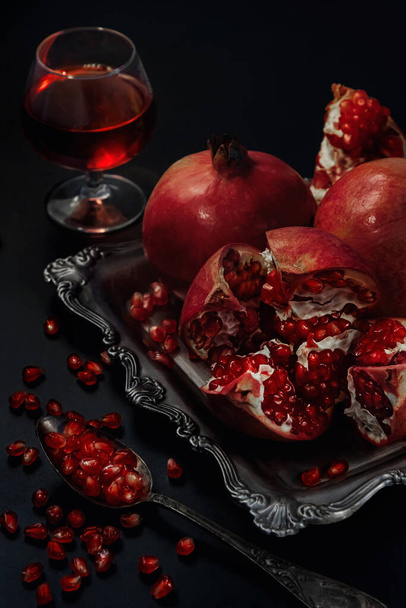 Still life of pomegranates on a black background - Valokuva, kuva