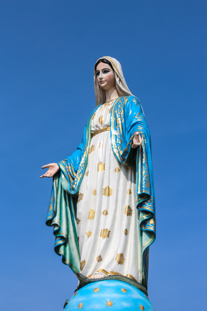 Статуя Девы Марии на голубом небе
. - Фото, изображение
