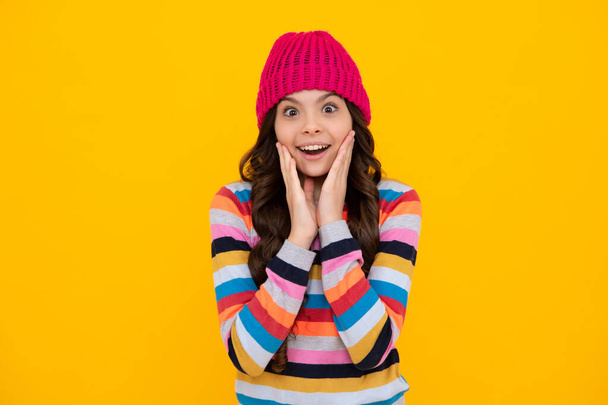 Winter hat. Cold season concept. Winter fashion accessory for children. Teen girl wearing warm knitted hat. Happy teenager, positive and smiling emotions of teen girl - Фото, изображение
