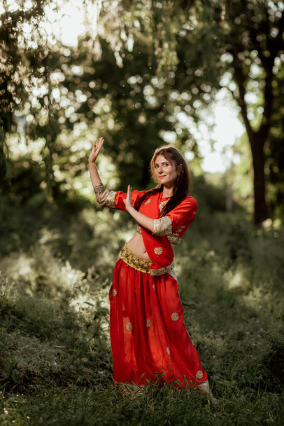 Дівчина вдягнена в національний індуський одяг червоного кольору. - Фото, зображення