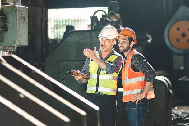 工業工場の建設機械のメンテナンスに従事する安全性の高いハード帽子を持つプロの技術者、生産技術の製造職業を持つ検査員 - 写真・画像