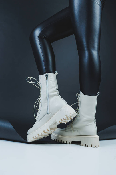 Gros plan des jambes féminines en cuir de mode élégant lacets blancs chaussures. Nouvelle collection saisonnière de chaussures d'hiver pour femmes. - Photo, image