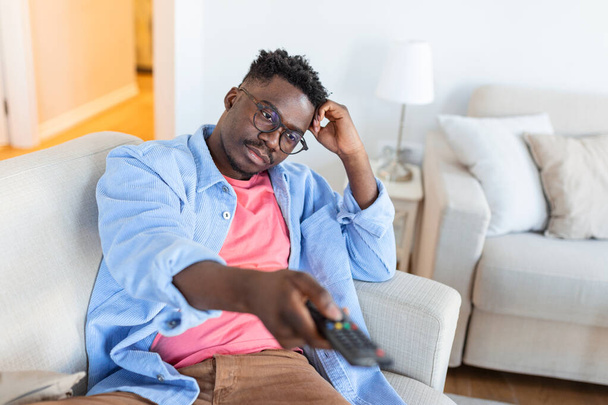 Heyecanlı Afro-Amerikalı, TV 'yi işaret eden kamera değiştirme kanalı TV izliyor. Televizyon Programı Reklamları. Seçici Odaklanma - Fotoğraf, Görsel