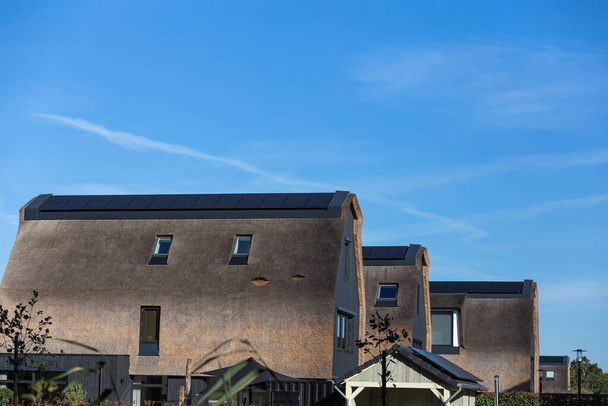 Panneaux solaires installés sur le toit de chaume d'une nouvelle maison - Photo, image