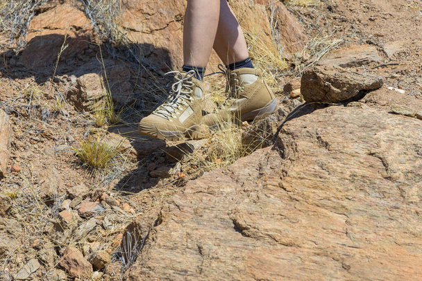 Oanob, Namibia - 28 September 2018: A tourist in the shoes of the renowned Meindl brand on the Oanob Park. Mountain, climbing and trekking shoes. - 写真・画像