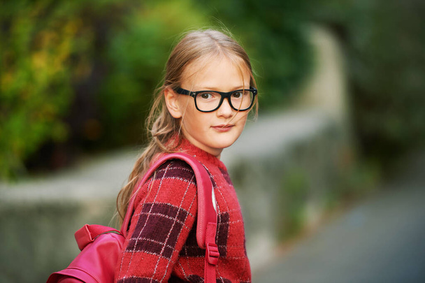 Retrato ao ar livre de adorável menina caminhando para a escola, mochila e óculos - Foto, Imagem