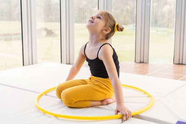 Little blonde girl with piggy tails playing with hula hoop - Foto, Bild