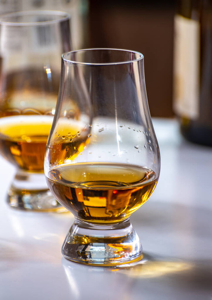 Verkostung von Whisky, Tulpenförmigen Probiergläsern mit einem Schuss Scotch Single Malt oder Blended Whisky auf weißem Tisch, Nahaufnahme - Foto, Bild