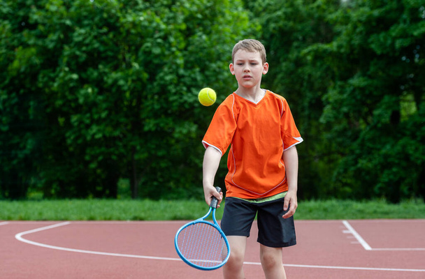 Lapsi tennismailalla tenniskentällä. Koulutus nuorelle lapselle, terveille lapsille. Horisontaalinen urheilu teema juliste, onnittelukortit, otsikot, verkkosivuilla ja sovellus - Valokuva, kuva