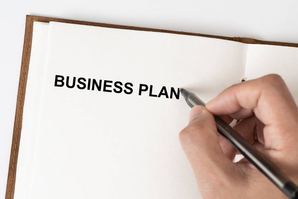 Plano de Negócios texto com uma pessoa segurando uma caneta em um livro de anotações - Foto, Imagem