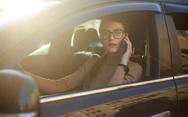Young confident business lady in glasses in the car, active independent woman lifestyle - Фото, изображение