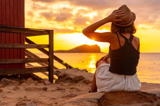 Woman with hat at sunset in Cala Comte beach on the island of Ibiza. Balearic - Fotoğraf, Görsel