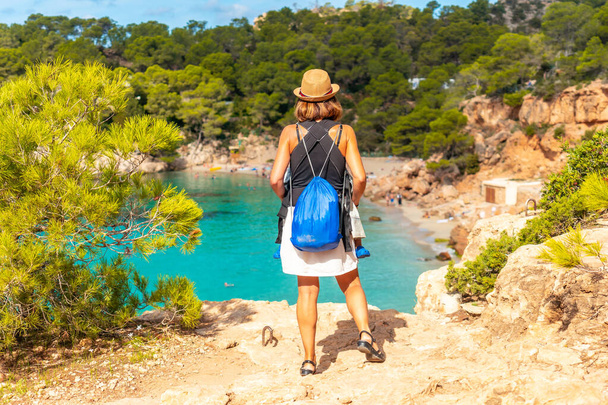 Concept de vacances, mère avec son bébé dans son sac à dos en direction de Playa Salada et Saladeta à Ibiza. Baléares - Photo, image