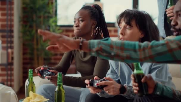 Diverse mensen met behulp van console om videospelletjes te spelen, plezier hebben met online gaming uitdaging op sociale bijeenkomst. Genieten van gameplay competitie op televisie en het drinken van bier. Handschot. - Video