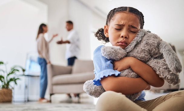 Parents fight, sad girl and teddy hug of a child crying from divorce in a home living room. Depressed kid, problem and youth anxiety of children depression from mama and dad family fighting. - Φωτογραφία, εικόνα