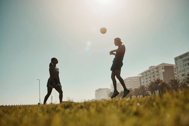Man, vrouw en voetbal spelen in gras park voor oefening, training spel en workout match. Fitnessvrienden, voetballers en sportteams spelen in de energiegezondheid wellness op het Portugese stadsveld. - Foto, afbeelding