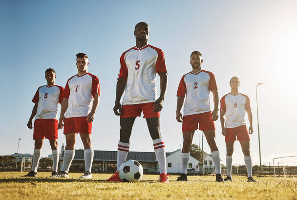 Soccer player, team and sports training on soccer field by men standing with ball, power and strong mindset. Football, fitness and man football players united in support on football field for workout. - 写真・画像