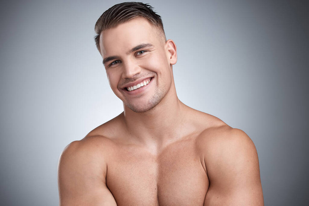 Chained myself to moving forward. Cropped studio portrait of a young confident man showing off his muscles against a grey background - Fotografie, Obrázek