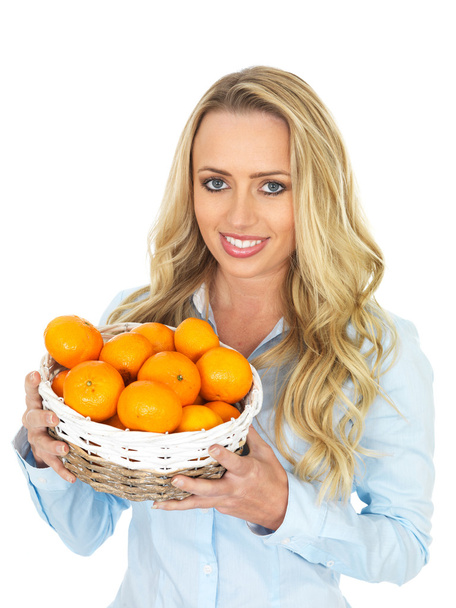 Mujer joven sosteniendo una cesta de mandarinas
 - Foto, Imagen