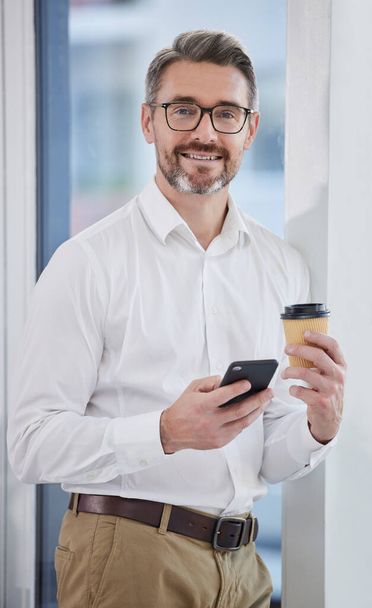 Starting my day the right way. a businessman using his smartphone while drinking coffee - Foto, immagini