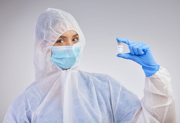 On aika lopettaa tämä pandemia. naispuolinen sairaanhoitaja, jolla on rokotepullo studion taustaa vasten - Valokuva, kuva